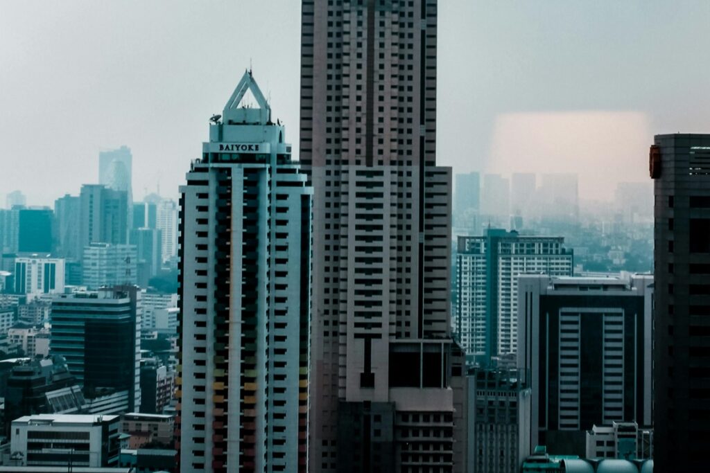 ภาพนี้แสดงถึงเมืองที่มีอาคารสูงขนาดใหญ่จำนวนมาก เห็นได้ว่ามีอาคาร Baiyoke อยู่ในกลุ่มอาคารสูง และมืดมIsa氛圍ในสภาพอากาศ ดังเด่นเหมือนกับ Shopee Live – กลยุทธ์การขายผ่านไลฟ์ที่ได้ผลจริง ซึ่งเป็นกลยุทธ์ที่ช่วยให้ผู้ขายมีโอกาสในการติดต่อลูกค้าได้อย่างมีประสิทธิภาพ และทำให้การขายของได้สำเร็จขึ้น โดยเชื่อมต่อสื่อสารกับลูกค้าในที่ตรงผ่านไลฟ์สด เช่นเดียวกับว่าอาคารสูงในภาพจะติดต่อสภาพแวดล้อมรอบข้างในเมือง
